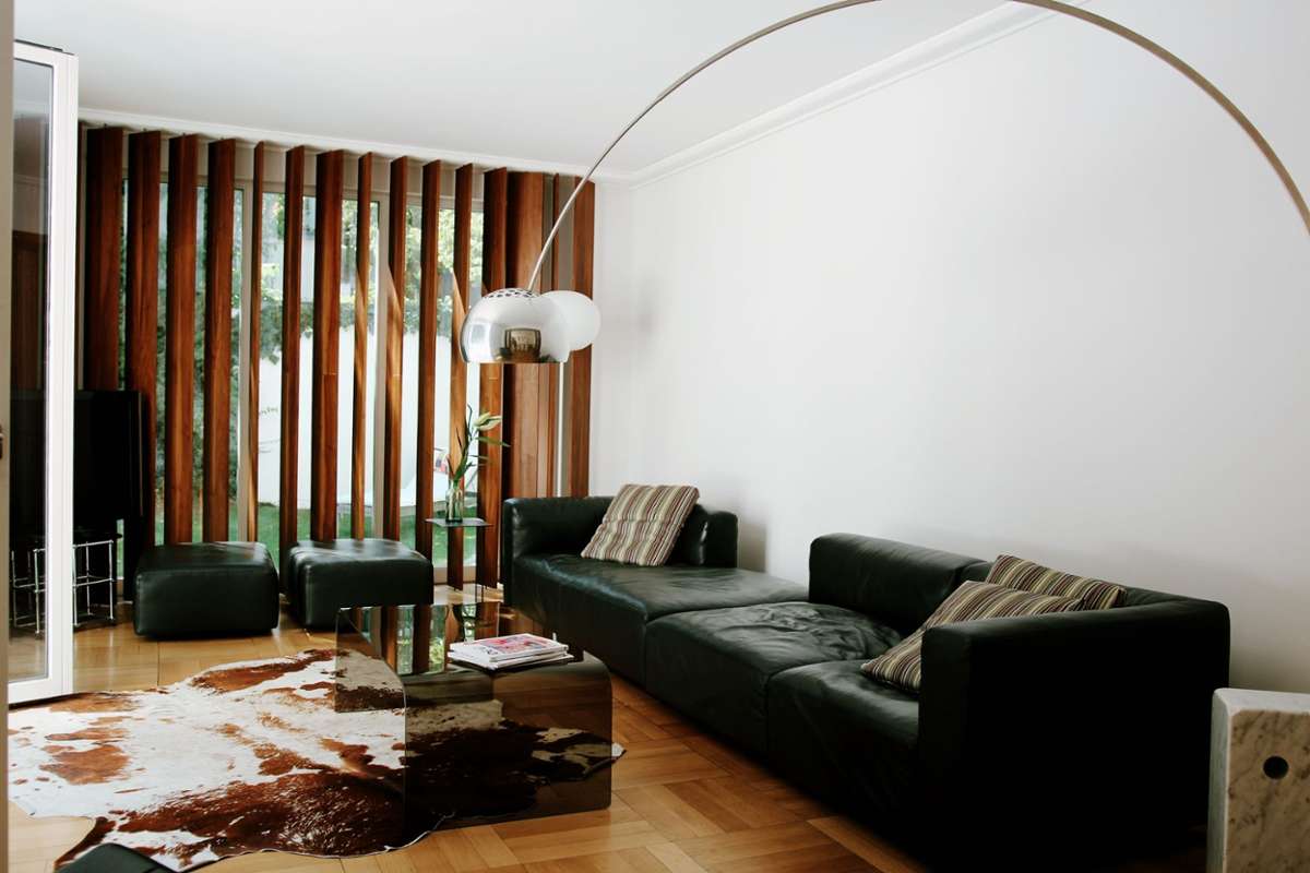 Das Knoll-Sofa ist ein Designklassiker und so langlebig wie alle Einrichtungs-Einzelstücke der Familie. Eine FLOS Arco Stehleuchte schwenkt sich stilvoll über das Sofa.
