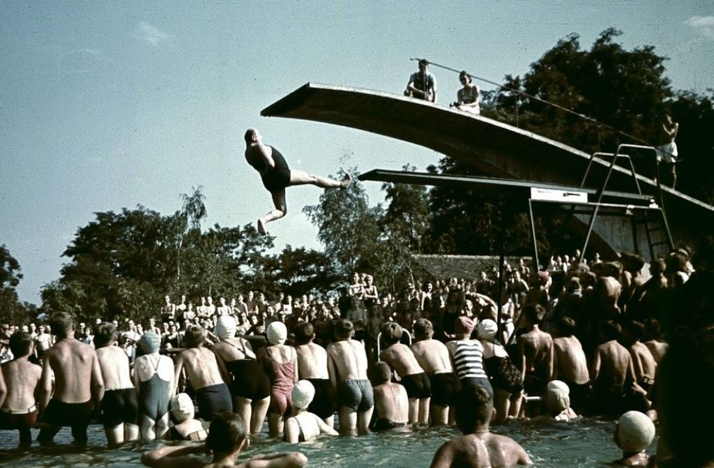 Zuschauer drängen sich auf diesem Foto aus den Vierzigern im Becken des Höhenfreibads Killesberg, um den Springern beim Bauchplatscher ins Wasser zuzusehen. Eröffnet wurde das Bad zwei Jahre zuvor, im Juni 1939 zur Reichsgartenschau, die den Anfang des Höhenparks markierte.