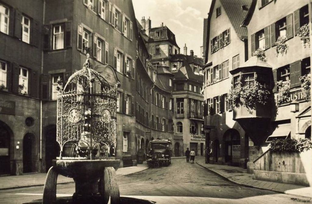 Die Straßen rund um den Hans-im-Glück-Brunnen in Stuttgart waren in den 1930er Jahren noch befahrbar. Der Brunnen, der diesem Quartier den Namen gibt, wurde 1909 von Josef Zeitler, einem gefragten Künstler dieser Zeit, geschaffen. Heute ist der Platz eine beliebte Anlaufstelle für Nachtschwärmer.