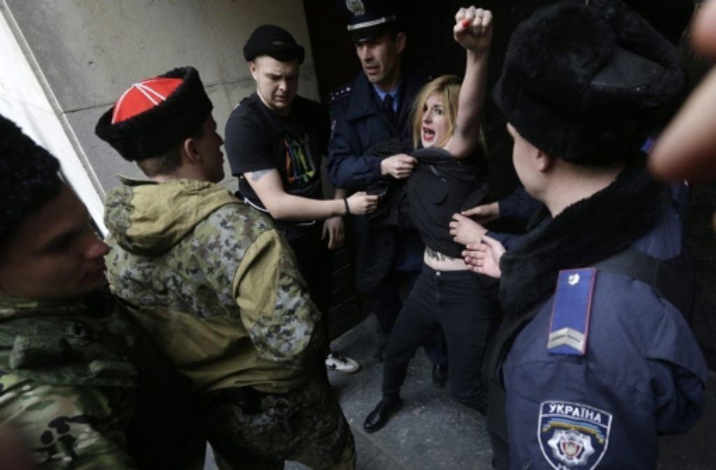 Zeitgleich rufen in Simferopol in der Ukraine Femen-Frauen ihre russlandkritischen Parolen.