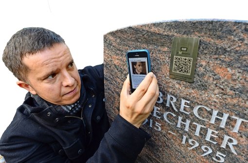 Der Bestatter Mark Ramsaier zeigt in Weilimdorf eine Trauerseite eines Verstorbenen. Die Trauerseite wird über einen QR-Code auf einem Grabstein angesteuert. Foto: dpa