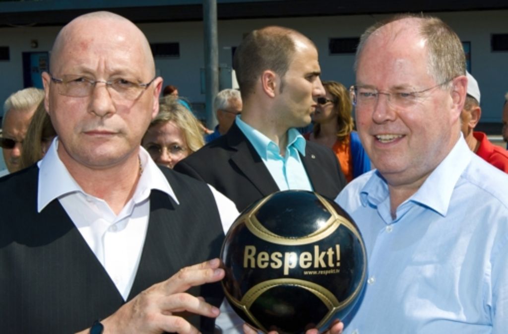 SPD-Kanzlerkandidat Peer Steinbrück (r.) und der Porsche-Betriebsratsvorsitzende Uwe Hück posieren am 08.07.2013 in Pforzheim (Baden-Württemberg) beim Sportverein FSV Buckenberg mit einem Respekt-Ball.