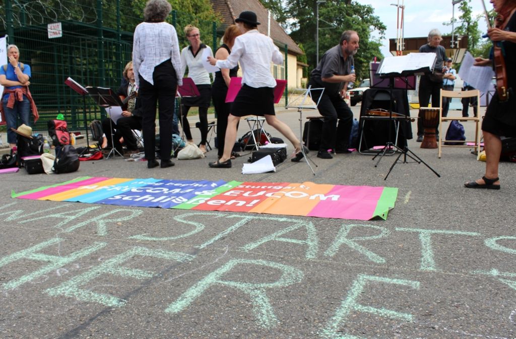 Mit Kreiden malten die Aktivisten Botschaften wie „War starts here“ auf den Boden. Seit 30 Jahren treten die Musiker des Netzwerks Lebenslaute deutschlandweit auf und verbinden zivilen Ungehorsam und Proteste für den Frieden mit klassischer Musik. Dieses Jahr setzt sich die Gruppe für das Ende von Africom ein.