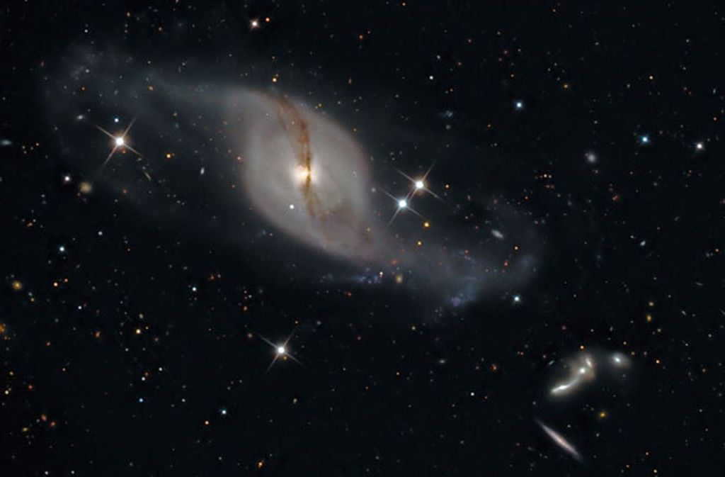 Die Galaxie NGC 3718 im Sternbild Großer Bär. Die Spiralarme wurden durch die Begegnung mit einer Nachbargalaxie auseinander gezogen.