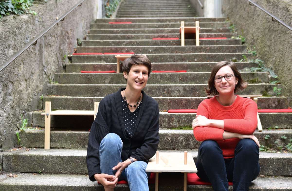 Sabine Fessler (links) und Christina Schmid sitzen auf einem Stäffele. In der Mitte ein eigens gefertigter Tisch zum Verweilen auf der Treppe. Foto: /Marion Jäger