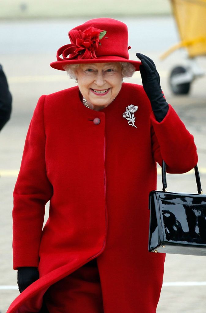 Lady in Red: Queen Elizabeth II von Kopf bis Fuß in Rot bei einem Besuch im im britischen Anglesey 2011. Selbst die Hutverzierung ist Ton in Ton gehalten.