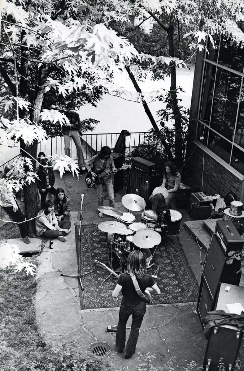 Eine Handvoll Fans wohnen der Konzertprobe im Freien in den 1970er Jahren bei.