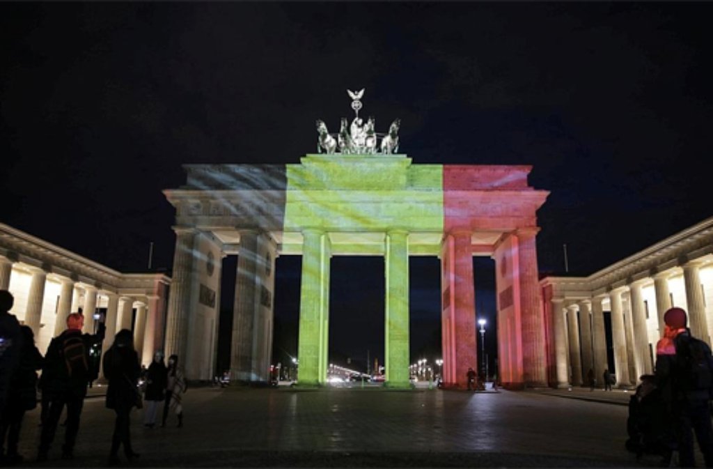 Auch in Berlin gedenken die Menschen den Opfern der Terrorattacken von Brüssel. Das Brandenburger Tor wird in den Farben der belgischen Trikolore angestrahlt.