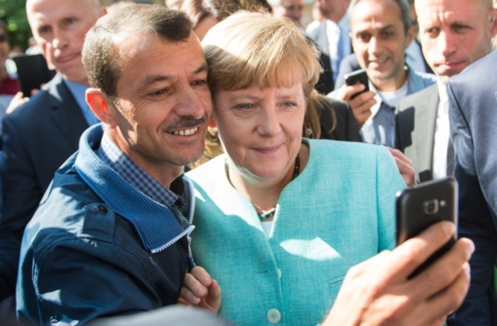 Heldin – Für die Menschen, die in Deutschland Schutz suchen, wird Angela Merkel zur Symbolfigur für ein offenes Europa. Nach dem Besuch einer Erstaufnahmeeinrichtung für Asylbewerber in Berlin-Spandau lässt sich Merkel für ein Selfie zusammen mit einem Flüchtling fotografieren.