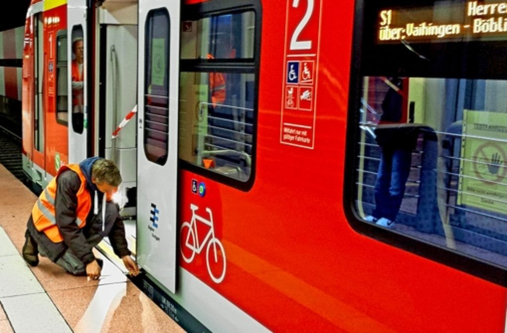 Szenen einer nächtlichen ET-430-Testfahrt mit modifiziertem Schiebetritt: im Hauptbahnhof misst ein Mitarbeiter den Abstand, daneben ein Blick ins System. Foto: Markus O. Robold