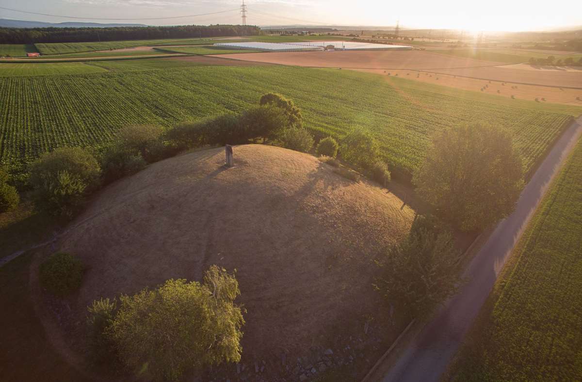 Die Sonne geht hinter einem rekonstruierten keltischen Hügelgrab auf (Luftaufnahme mit Drohne).