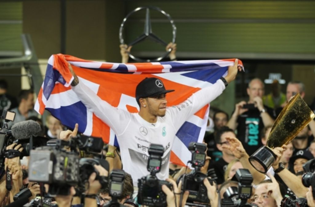 Triumphreise: Lewis Hamilton holt sich zum zweiten Mal die Weltmeisterschaft und zeigt im Mercedes Flagge.