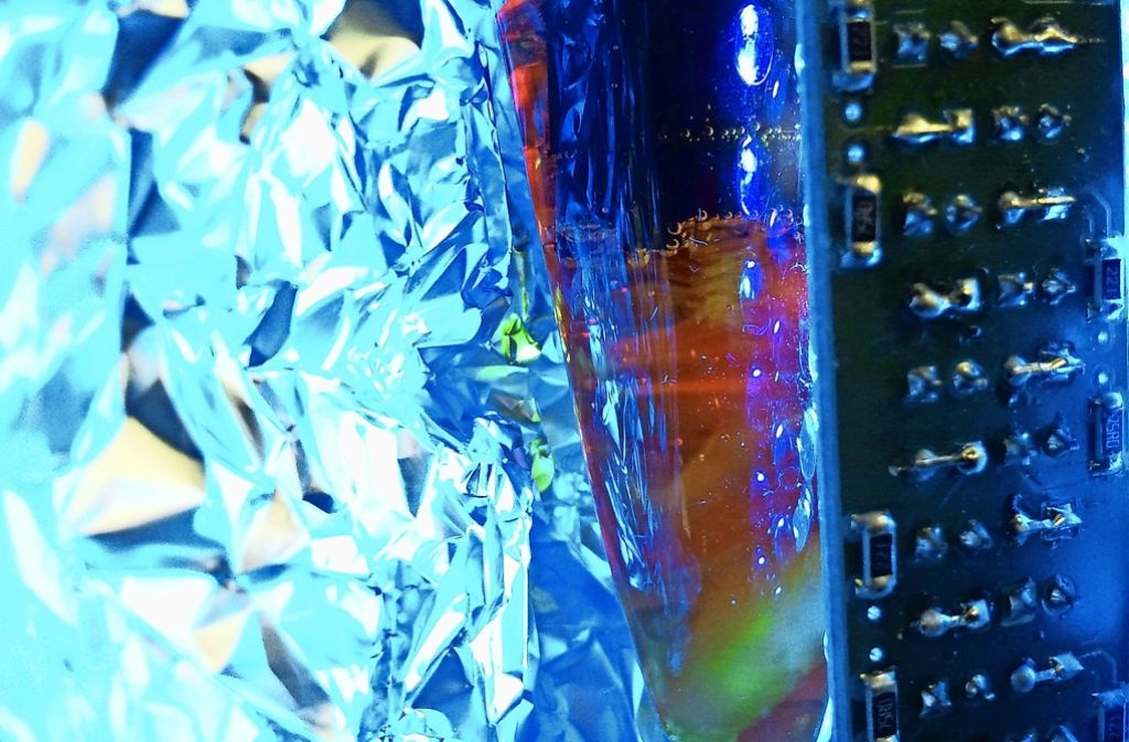 Im Labor der Ulmer Forscher entsteht unter dem Einfluss von Licht aus Wasser Sauerstoff – zu erkennen an den kleinen Gasbläschen im Reaktionsgefäß (Bildmitte). Foto: Universität Ulm