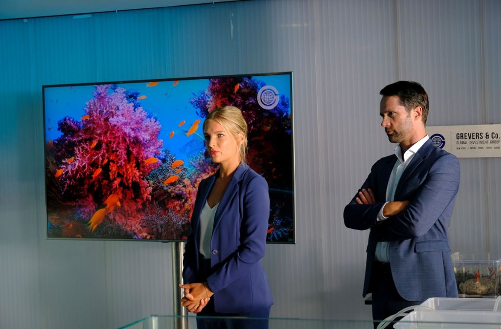 Dr. Julika Bergmann (Bea Brocks) stellt sich und das Projekt „Rote Koralle - Erneuerung eines Riffs“ potenziellen Investoren vor, die der Geschäftsmann Simon Grevers (Matthias Schloo) eingeladen hat.