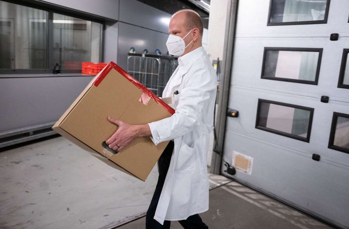 Holger Hennig, Leiter der Apotheke des Klinikum Stuttgart, trägt erste für das Impfzentrum bestimmte Dosen des Covid-19 Impfstoffes in einer Versandbox.