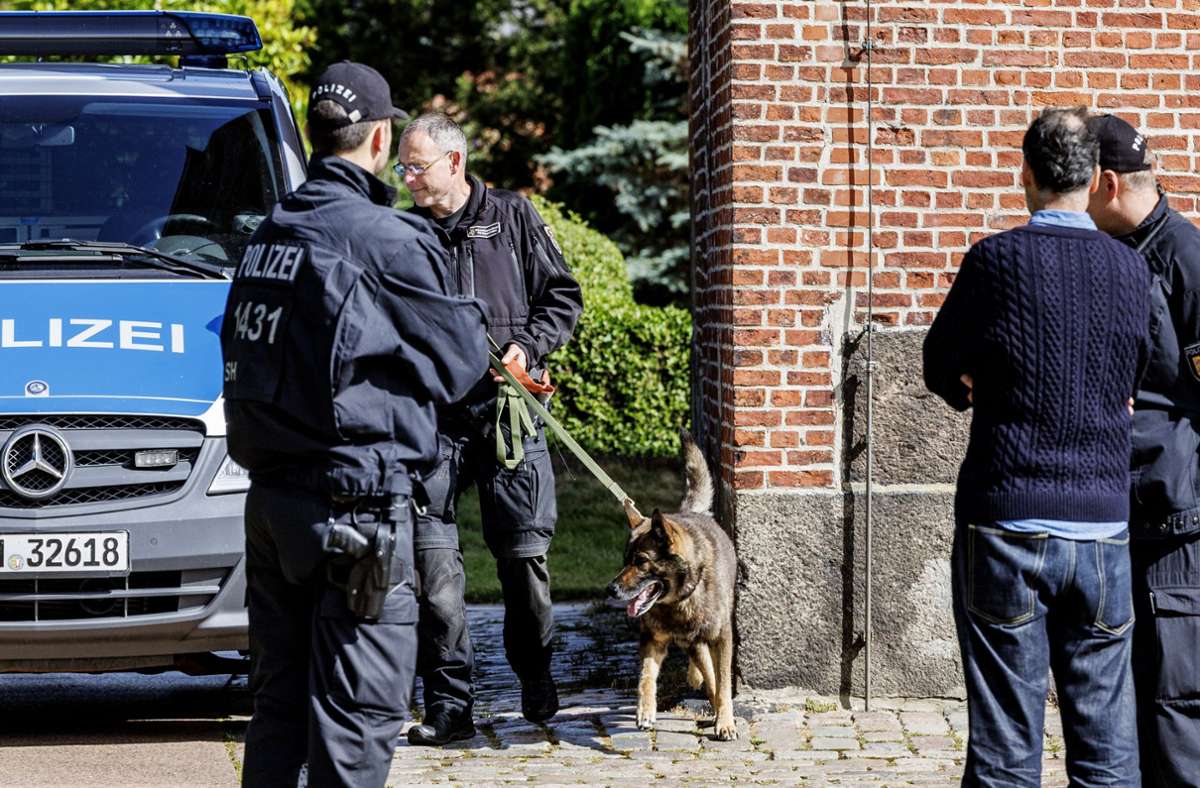 Einsatzkräfte der Polizei untersuchen am Samstag mit Hunden die Kirche.