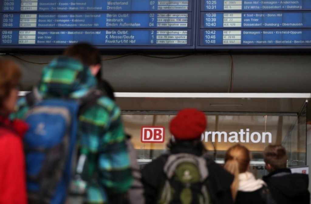 Bahnreisende stehen in Köln (Nordrhein-Westfalen) an einem Informationsschalter am Hauptbahnhof.