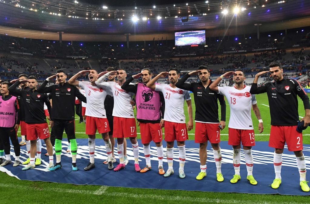 Spieler der türkischen Nationalmannschaft salutieren nach dem EM-Qualifikationsspiel gegen Frankreich im Saint-Denis-Stadion. Foto: AFP/Alain Jocard