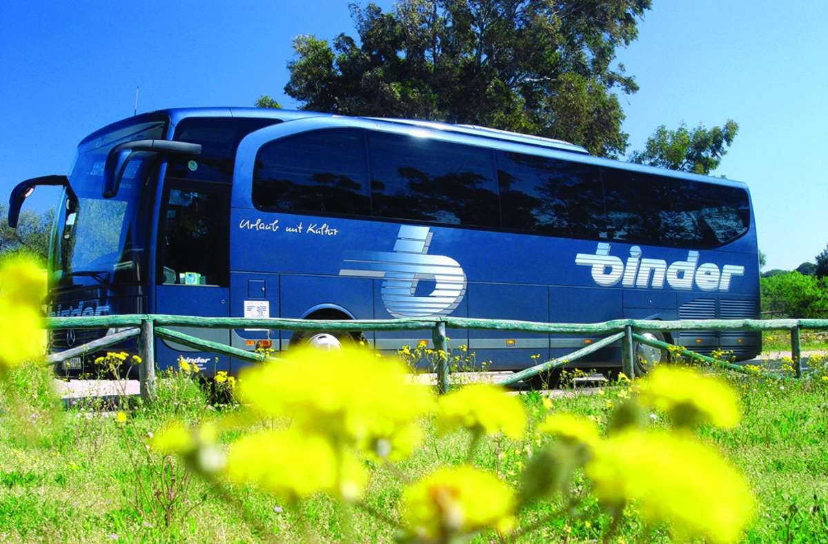 Bus der Firma Binder aus Stuttgart auf der Fahrt durch eine blühende Landschaft.