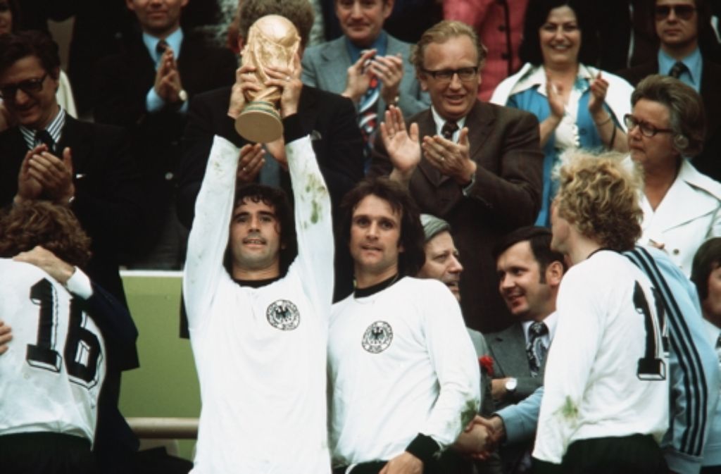 Riesig war die Freude, als Deutschland die Weltmeisterschaft 1974 vor heimischer Kulisse gewann. Das Bild zeigt Gerd Müller mit Wolfgang Overath und Uli Hoeneß, die den begehrten Pokal hoch in die Lüfte halten.