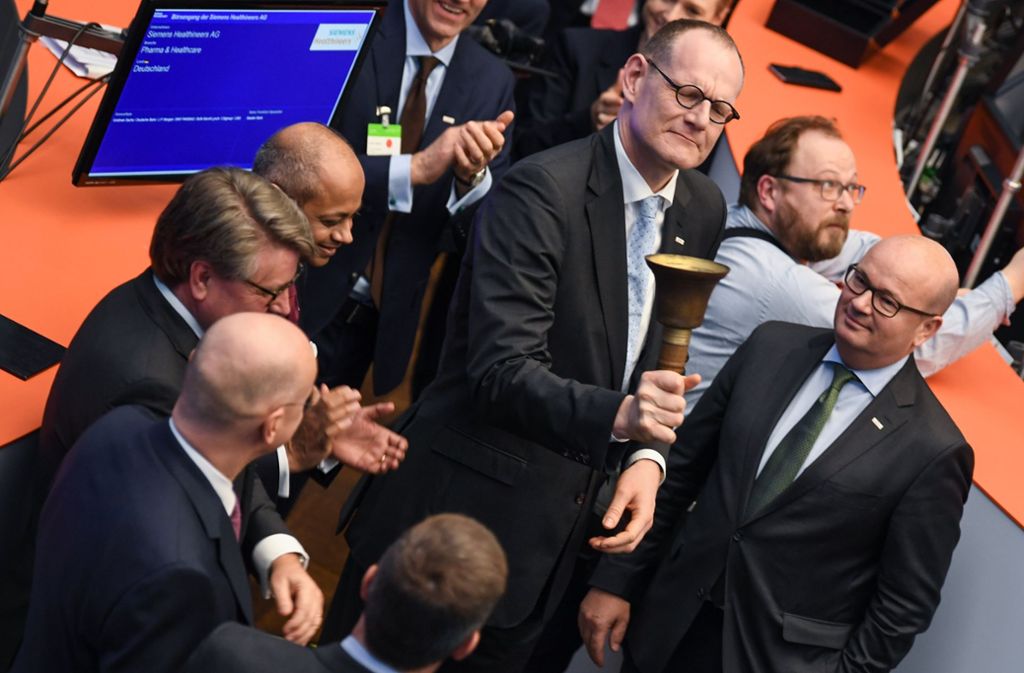 Bernd Montag,  Vorstandsvorsitzender der Siemens Healthineers AG, schwingt auf dem Parkett der Frankfurter Wertpapierbörse die Börsenglocke. Foto: dpa