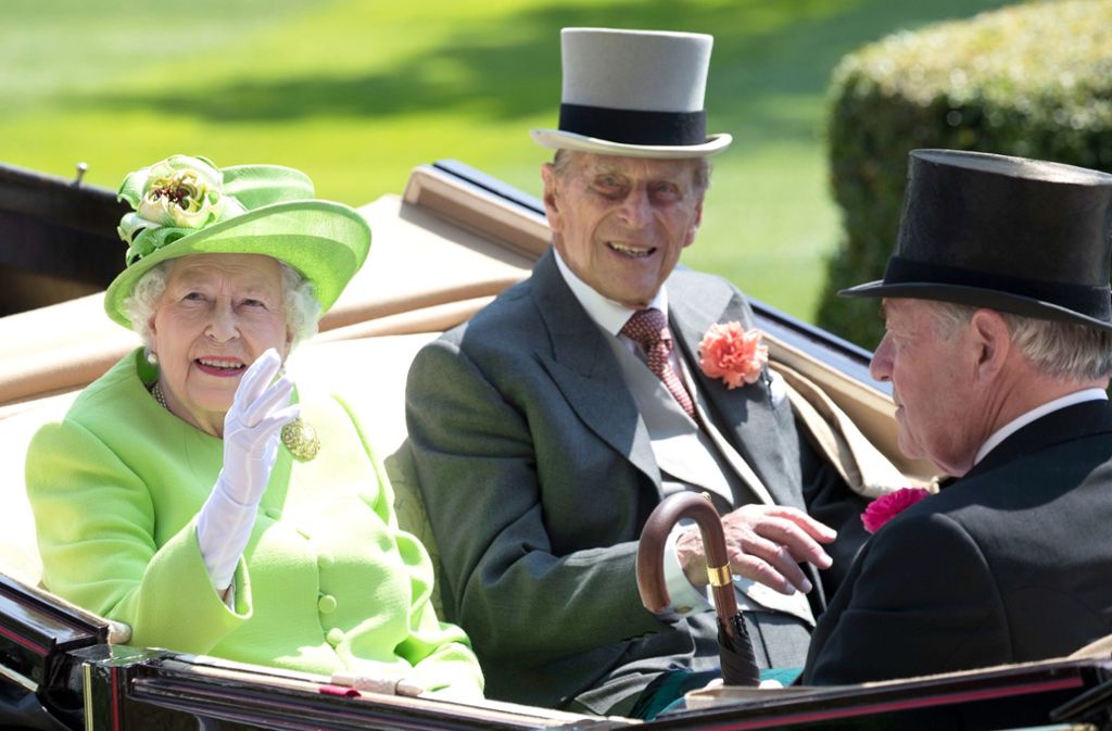 Königin Elizabeth fährt gemeinsam mit ihrem Ehemann Prinz Philip über die Rennstrecke und winkt den Zuschauern.