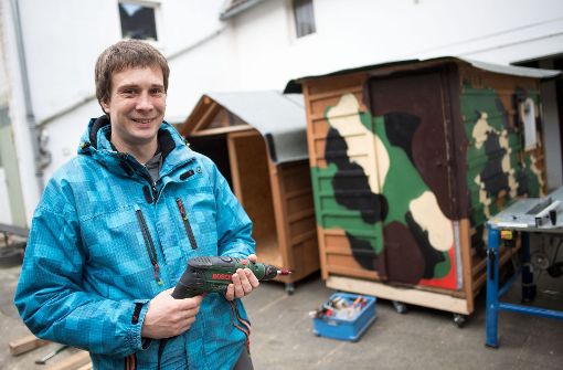 Sven Lüdecke zimmert kleine Wohnboxen für Obdachlose zusammen. Foto: dpa
