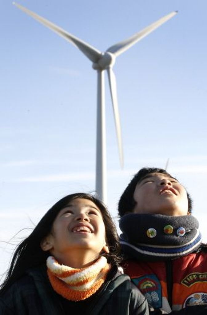 Die Geschwister Fuu und Kaito Nishikata aus Fukushima schauen sich bei Berlin Windkraftanlagen an. So könnte bald auch in Japan Energie gewonnen werden.