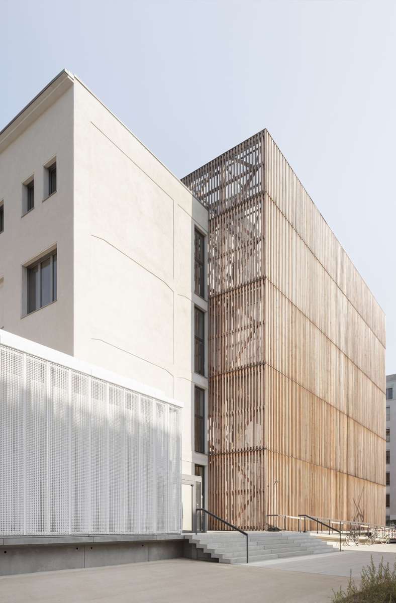 Beim Umbau der Hochschule für Schauspielkunst Ernst Busch in Berlin haben die Architekten von O & O Baukunst die ehemaligen Opern-Werkstätten aus den Fünfzigerjahren um einen von Holzlatten umhüllten Bühnenturm und eine Cafeteria erweitert.
