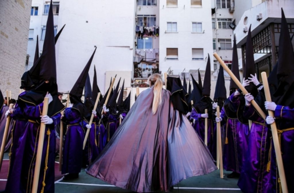 „Nazarenos“, zu deutsch „Büßer“, warten in Malaga auf den Beginn der Oster-Prozession.
