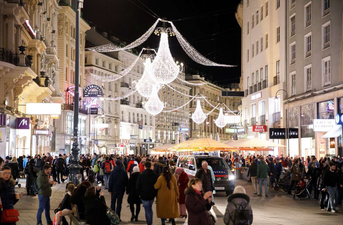 Österreich, Wien: Eine Polizeistreife fährt durch die Wiener Innenstadt, wo sich einige Menschen versammeln. Zum Jahreswechsel 2021/2022 gibt es wegen der Corona-Pandemie keinen Silvesterpfad und in der Gastronomie wurde eine Sperrstunde um 22 Uhr verhängt.