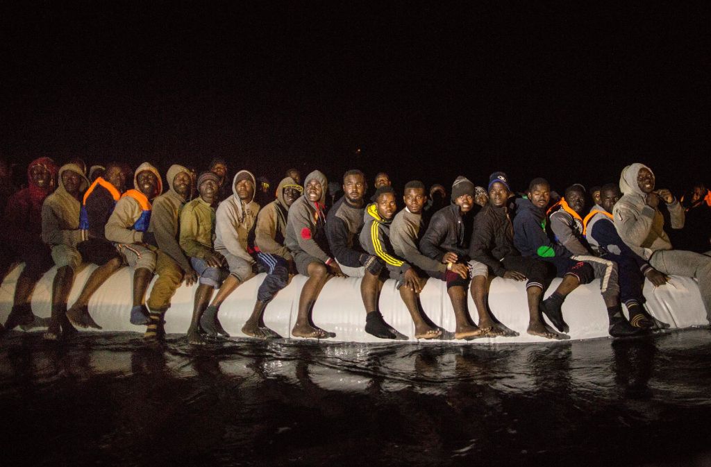 Auf einem überfüllten Schlauchboot warten diese Menschen im Mittelmeer auf ihre Rettung. Foto: AP