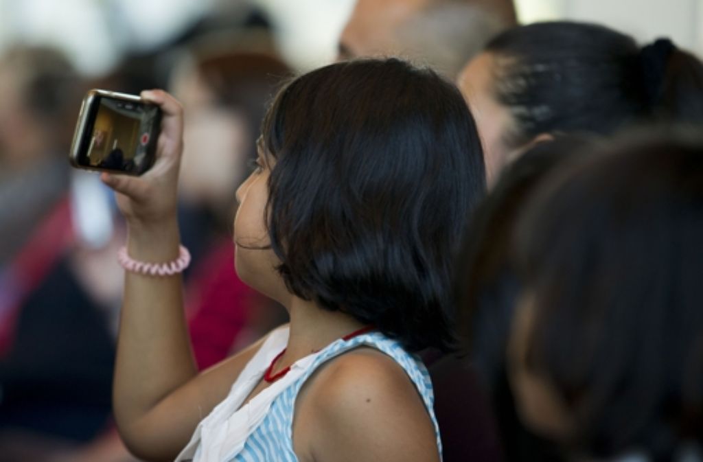 Ein Mädchen fotografiert die Zeremonie im Stuttgarter Rathaus mit dem Handy.