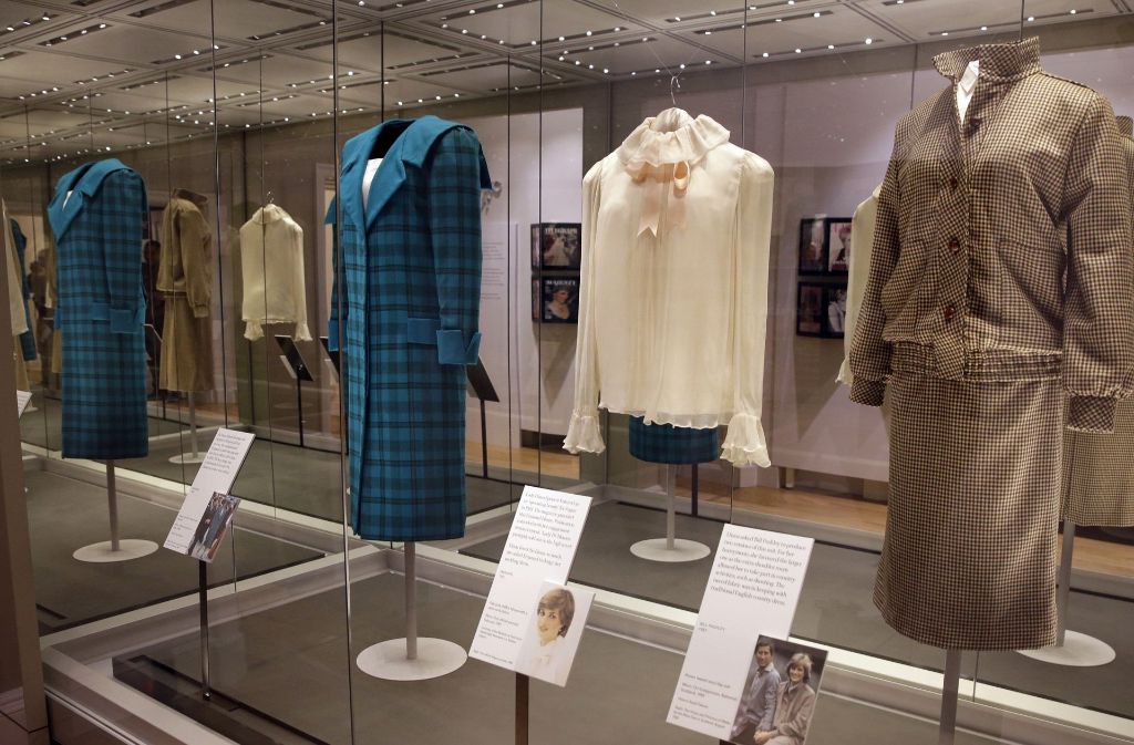 Der karierte Wollmantel, den Prinzessin Diana bei einem Besuch in Italien im Jahr 1985 getragen hat (von links nach rechts), die blass-rosafarbene Chiffon-Bluse vom ersten offiziellen Porträttermin im Jahr 1981 und das braune Tweedkostüm, das Diana während der Flitterwochen im Jahr 1981 in Balmoral trug, gehören zu den Exponaten der Ausstellung „Diana: Her Fashion Story“.
