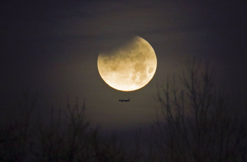 Über dem Bundesstaat North Carolina leuchtete der Mond fast schon golden. Zum Vergleich, wie groß der Mond aussah, fliegt unter ihm ein Flugzeug.