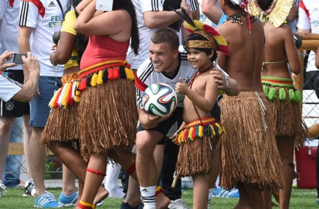 Lukas Podolski inmitten von brasilianischen Eingeborenen.