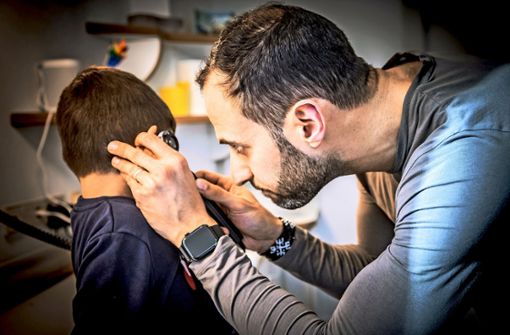 Der Facharzt für Kinder- und Jugendmedizin Özgür Dogan in seiner Praxis mit einem fünfjährigen Jungen während der U-9-Untersuchung. Foto: Lichtgut/Julian Rettig