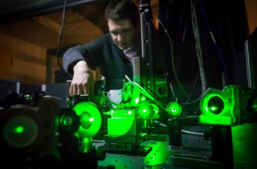 Der Quantencomputer im Labor an der Universität Stuttgart ist nur wenige Millimeter groß und wird auf dem optischen Tisch vom Physiker Gerald Waldherr mit grünem Laserlicht und Radiowellen manipuliert. Foto: Achim Zweygarth