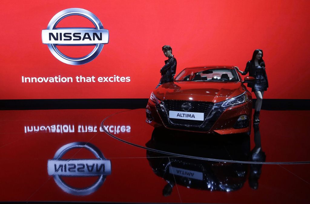 Zwei Models präsentieren einen Nissan Altima, während ...