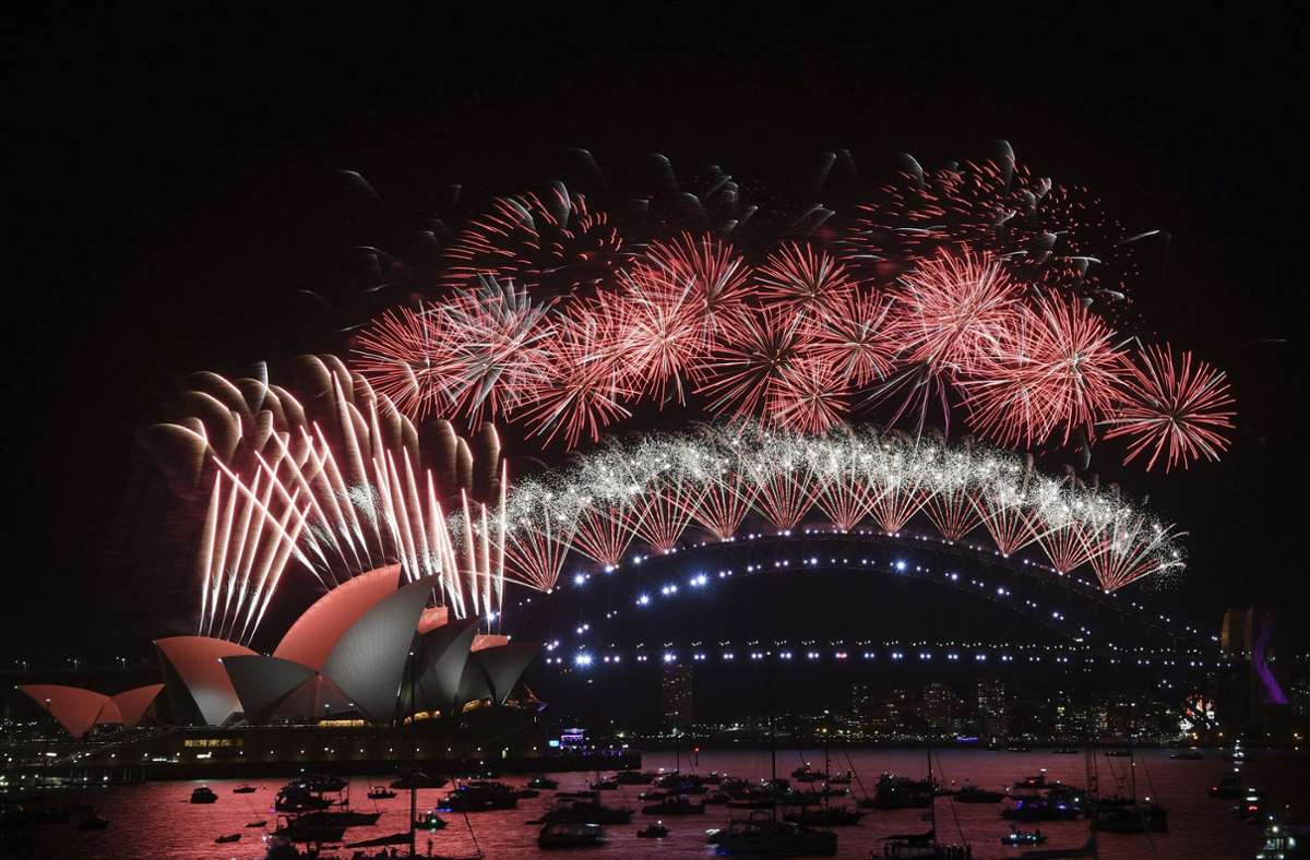 Australien, Sydney: Feuerwerkskörper explodieren über dem Opernhaus und der Harbour Bridge von Sydney während der Silvesterfeierlichkeiten.