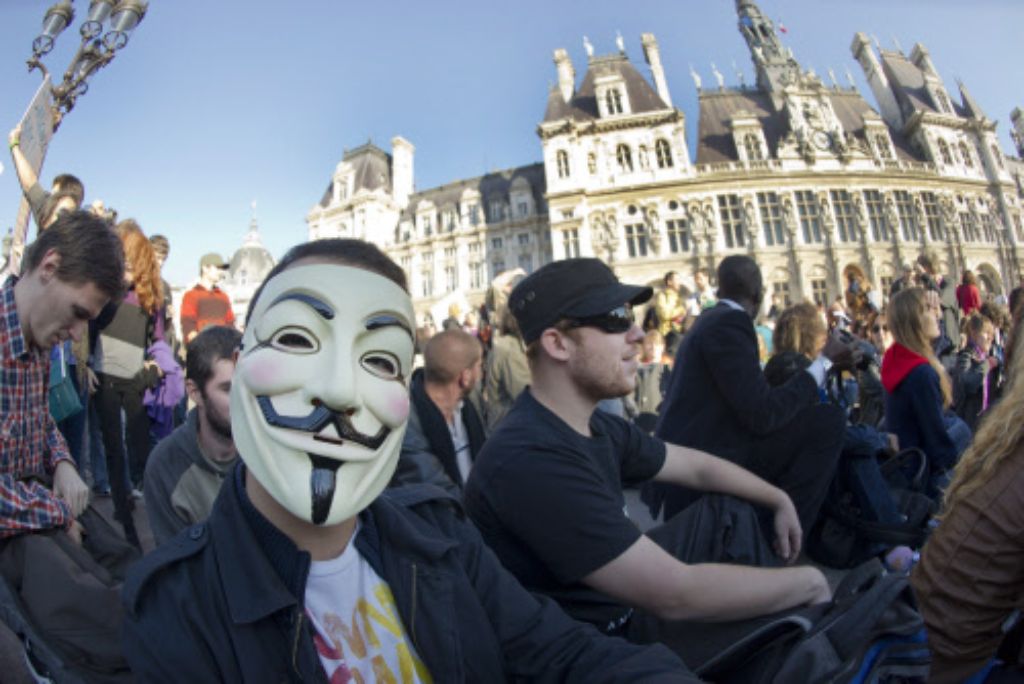 Viele Demonstranten setzen sich eine Maske von Guy Fawkes auf.