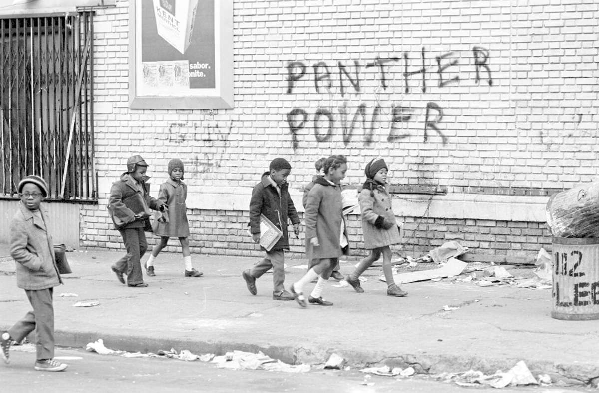 Kinder laufen an einem „Panther Power“-Graffiti vorbei.