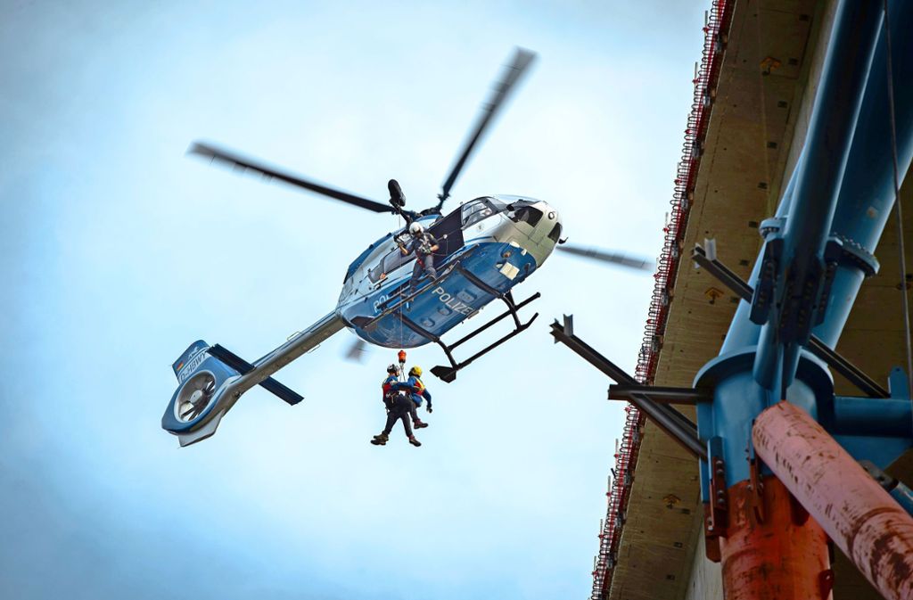 Millimeterarbeit in schwindelnder Höhe: Der Polizeihubschrauber setzt die Luftretter der Bergwacht auf einer kleinen Bauplattform in 70 Metern Höhe ab.