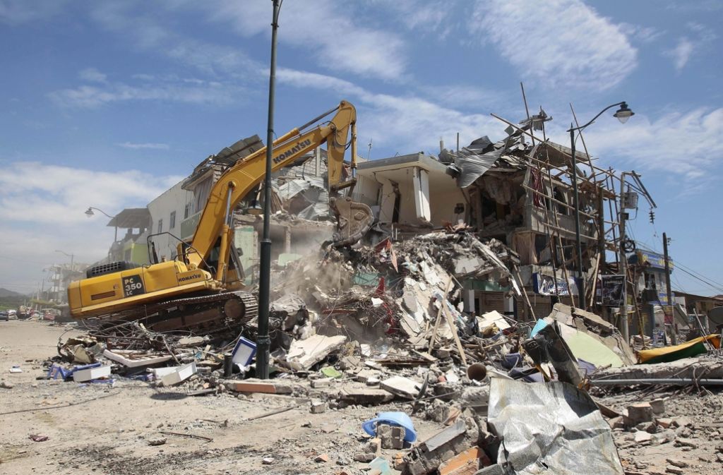 Ein Bagger zerlegt das schon halb zerstörte Gebäude in Pedernales im Norden von Ecuador.