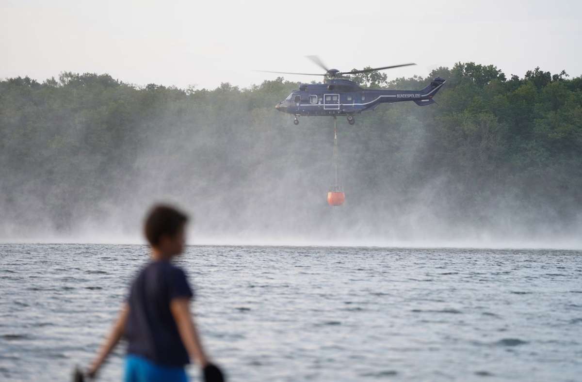 Brandenburg, Seddin: Ein Hubschrauber der Bundespolizei nimmt Wasser auf am Seddiner See, um die Waldbrände in Treuenbrietzen und Beelitz zu bekämpfen.
