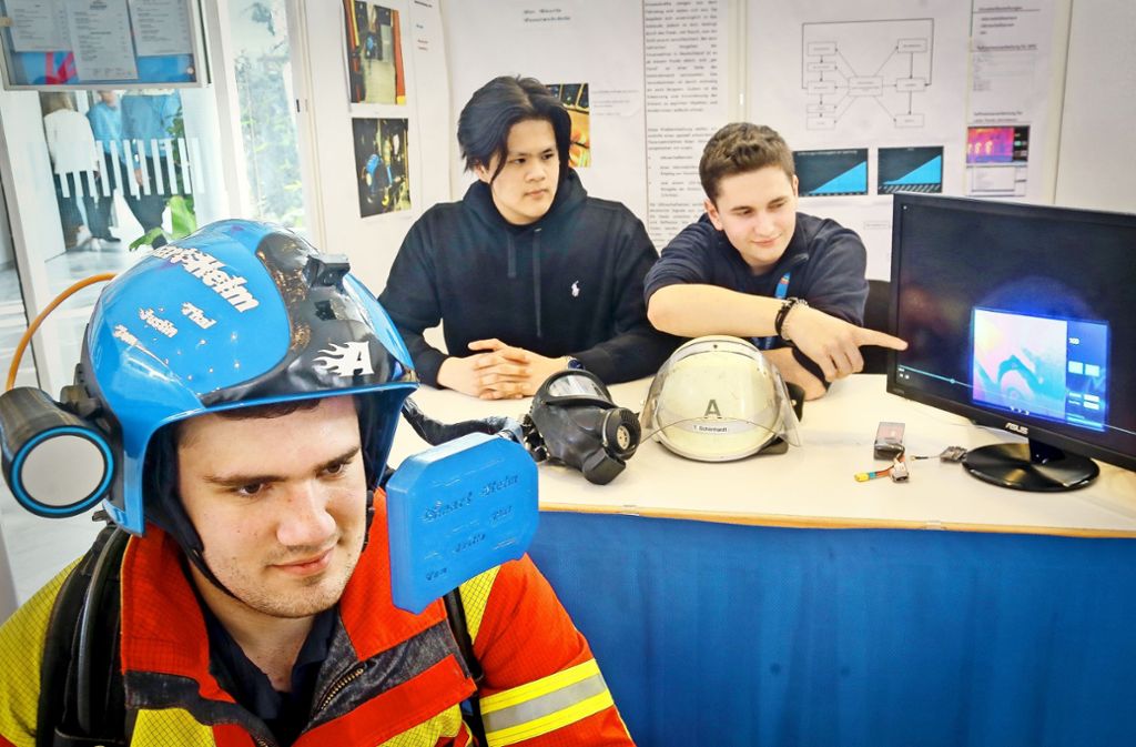 Die Abiturienten Tom (mit Helm), Thai Son und Justin des Berufsschulzentrums Leonberg tüfteln am Feuerwehrhelm der Zukunft.