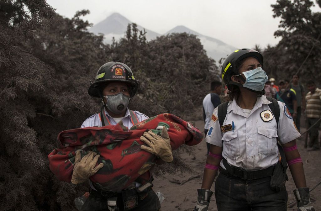 Eine Feuerwehrfrau trägt in Guatemala den leblosen Körper eines Kindes in den Armen. Es hatte keine Überlebenschancen.