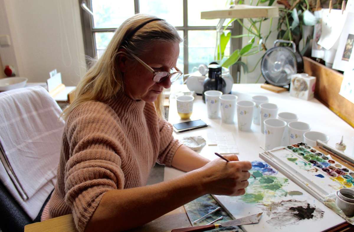 Zum Team der Manufaktur gehören auch Kunstmaler wie Annette Reimann. Sie bemalt Coffee-to-Go-Becher mit einem Bienenmotiv.