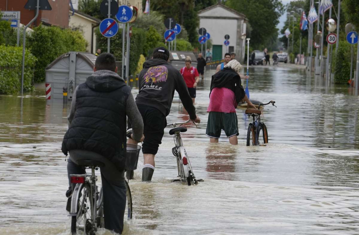 Barbiano di Cotignola: Ein Mann fährt auf einem Fahrrad eine überflutete Straße entlang.