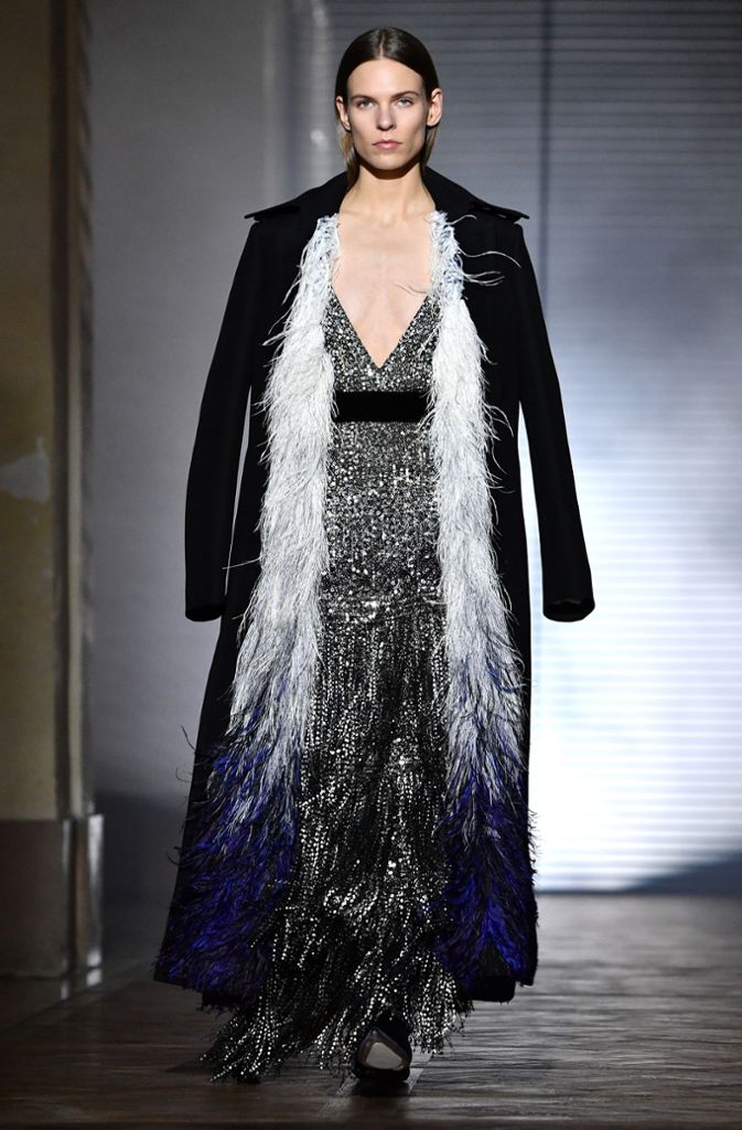 Sehr weiblich kommt der Look von Givenchy daher: Zum tiefen Dekolleté, Pailletten und Fransen kombiniert das französische Modehaus einen langen Blazer.